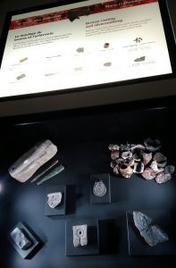 Vitrine présentant des objets avec un panneau les détaillant au-dessus